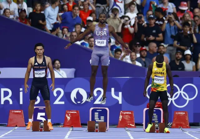 Lyles spring jumps before getting set on the blocks