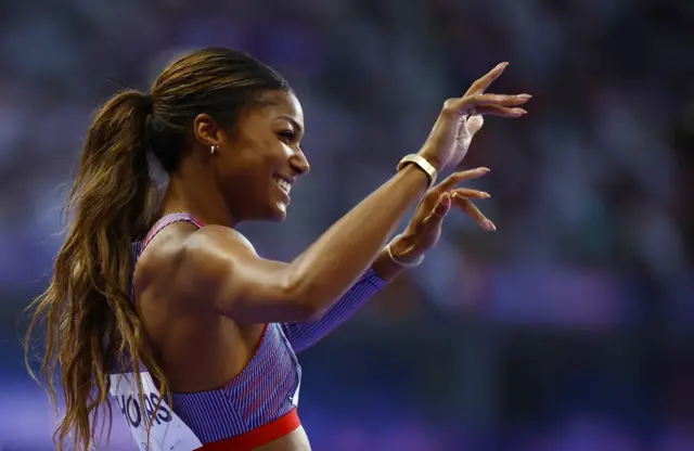 Thomas waves at the crowd after winning her race