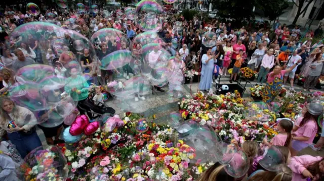 Bubbles floating above a floral tribute at a vigil in Southport