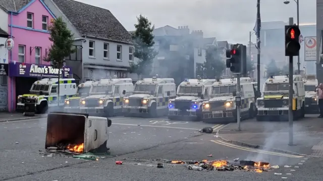 Police vans block a road in Belfast