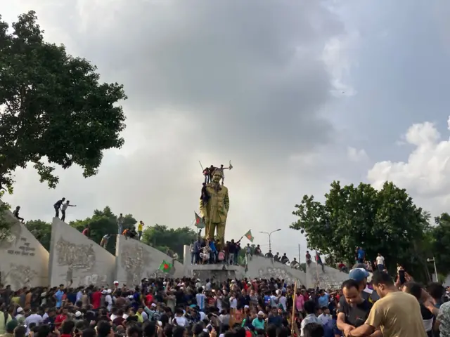 Protesters on top of the statue of of former Bangladeshi President Sheikh Mujibur Rahman in Ganabhaban