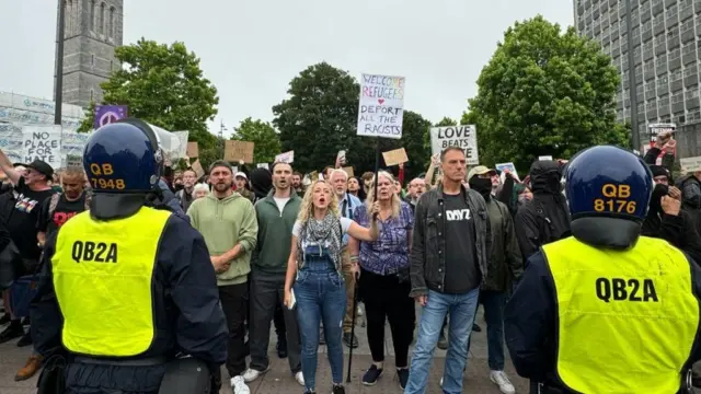 Demonstrators facing a line of riot police