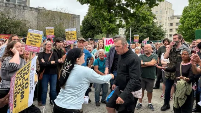 A woman pushes a man during pro and anti-immigration demonstrations in Plymouth.