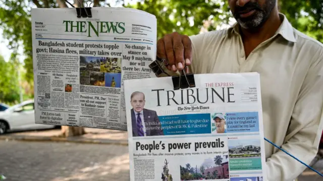 A vendor displays the front page of newspapers with articles on Bangladesh, along a roadside in Islamabad.