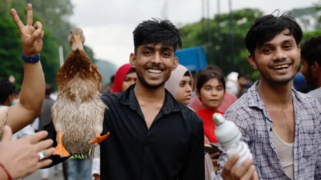 People remove a live duck and an electric bulb from the Ganabhaban, the prime minister's residence, after the resignation of PM Sheikh Hasina in Dhaka, Bangladesh.