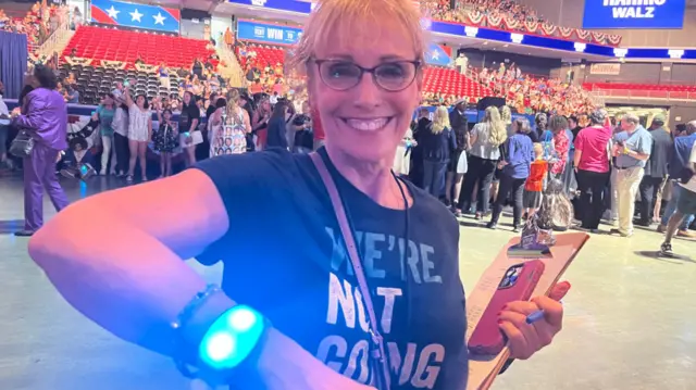 A Democratic party supporter shows her wristband at a Harris rally