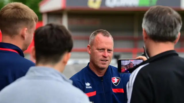 Cheltenham boss Michael Flynn being interviewed by reporters