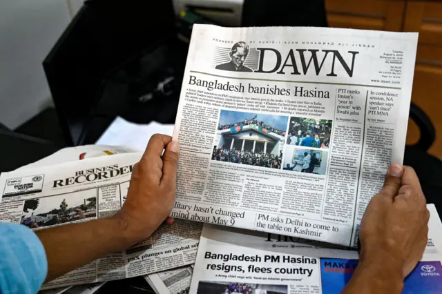 A man reads the front page of a newspaper with an article on Bangladesh in Islamabad.