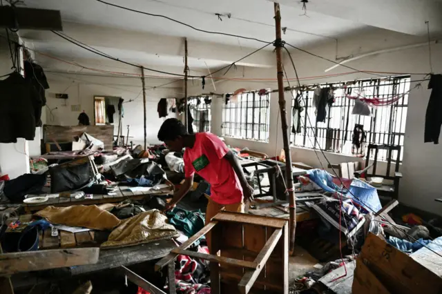 A man looks through the damage at a vandalised police station in Bangladesh