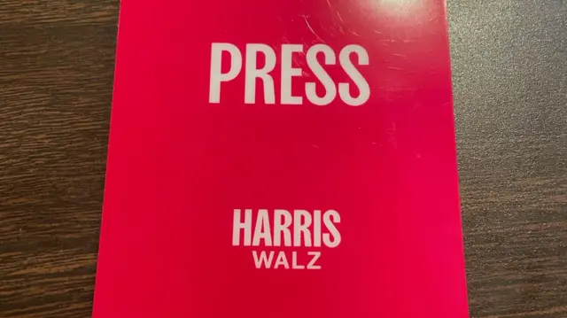 Pink press pass which reads 'Harris-Walz'