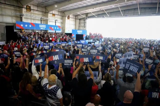 Supporters listen to speakers while waiting for U.S. Vice President Kamala Harris and her running mate Minnesota Governor Tim Walz to arrive at a campaign rally in Romulus, Michigan, U.S., August 7, 2024.