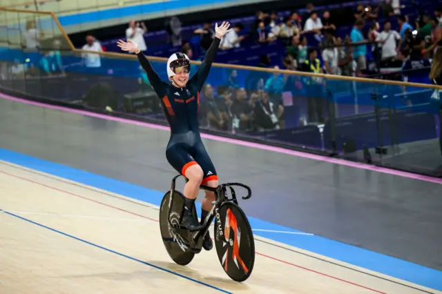 Great Britain's Emma Finucane with her hands in the air while on her bike