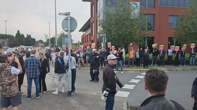 Police keep two groups of protesters on either side of a road