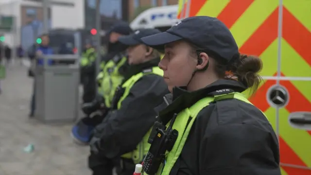 A line of police officers, taken side-on.