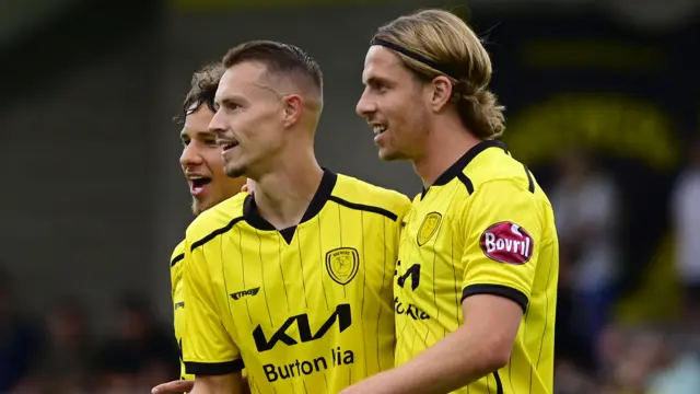 Burton striker Billy Bodin (centre) celebrates a goal with team-mates