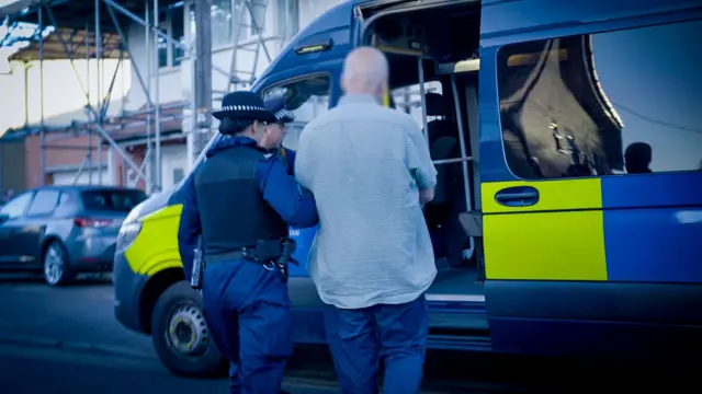 Police of officers making an arrest in Sutton, south London, following last week's violent disorder in Whitehall.