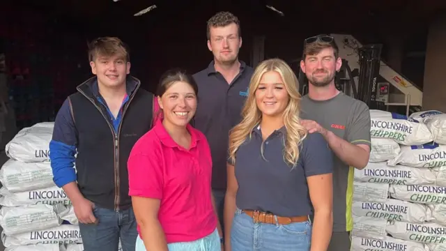 Young people from the Corringham Young Farmers' Club standing in front of potatoes