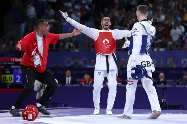 Zaid Kareem of Team Jordan (red) celebrates following victory against Bradly Sinden of Team Great Britain (blue)