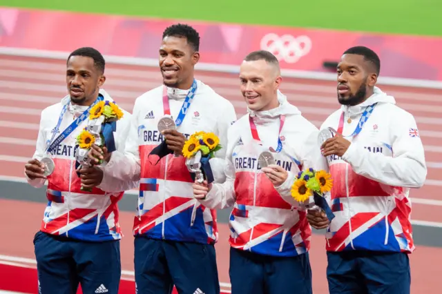 CJ Ujah, Zharnel Hughes, Richard Kilty and Nethaneel Mitchell-Blake of Great Britain with their silver medals on the podium after the men's 4 x 100m relay at the 2020 Tokyp Olympics