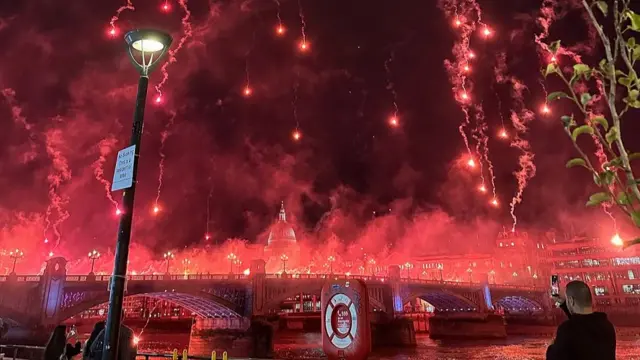 Bright red flares and fireworks over Southwark Bridge with the St Pauls Catherdral in the background