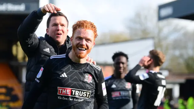 Exeter boss Gary Caldwell stands behind Ryan Woods