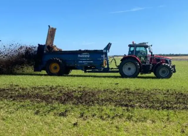 Red tractor pulling a blue trailer