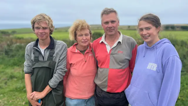 Some of the Amiss family stand in a field: Harold, Rona, Neville, and Dora