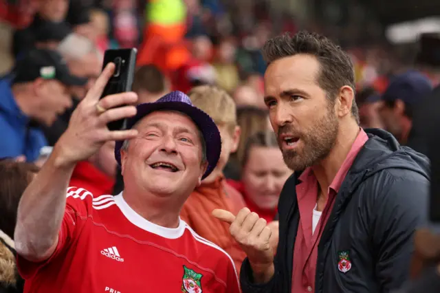 Wrexham co-owner Ryan Reynolds (right) poses for a picture with a Dragons fan
