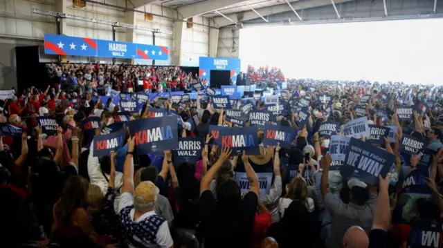 Supporters listen to speakers while waiting for U.S. Vice President Kamala Harris and her running mate Minnesota Governor Tim Walz to arrive at a campaign rally in Romulus, Michigan, U.S., August 7, 2024.