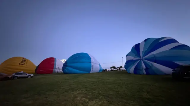 Hot air balloons laid out on the floor.