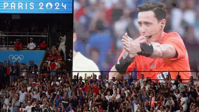 Giant video screen showing the referee pointing to the penalty spot for France as they play Spain in the men's football final at the Paris 2024 Olympics