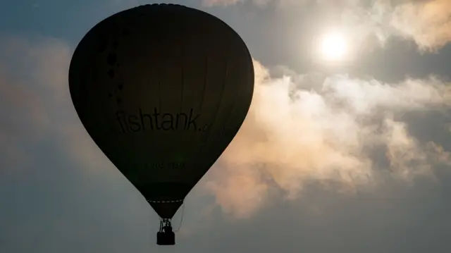 A balloon floats past the sun