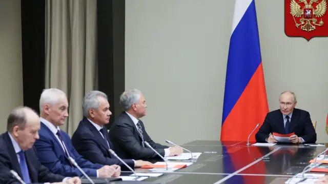 President Putin sits at the head of a table with members of Russia's security council