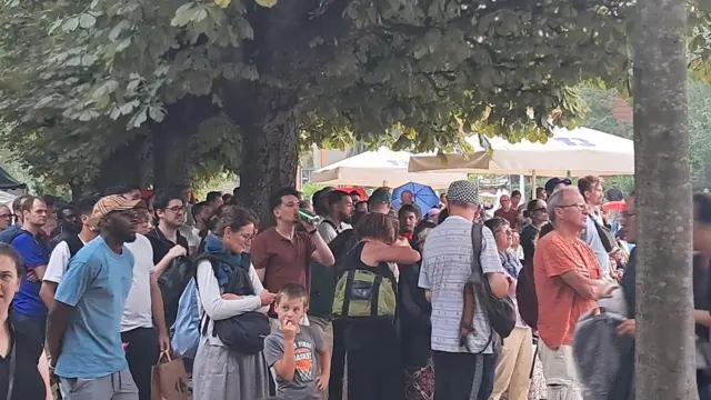 French football fans gather under a tree