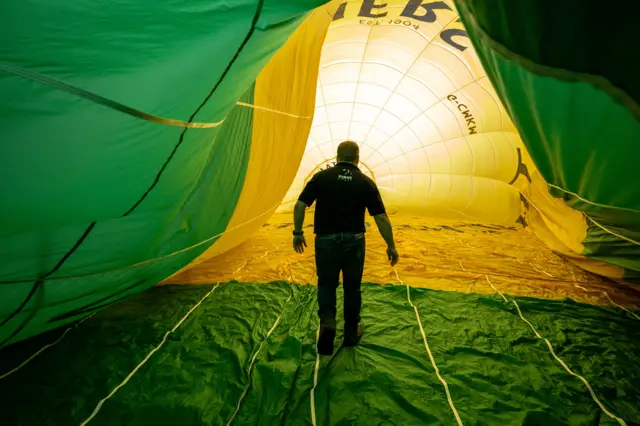 Man stood inside a green and yellow balloon canopy