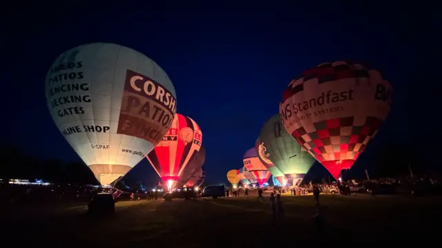 Hot air balloons. They are tethered but inflated and lit up with fire.