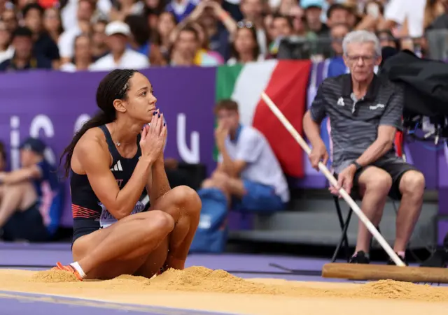 Katarina Johnson-Thompson on her knees in the sand after one of her long jumps