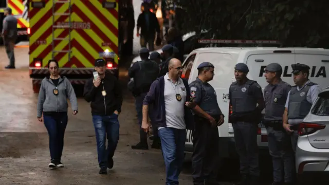 First responders huddle together while responding to the Brazil plane crash