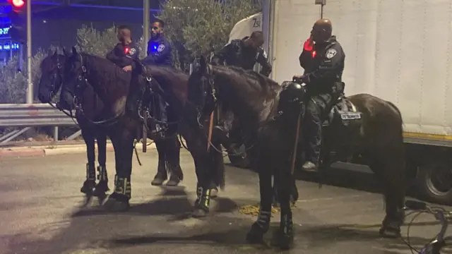 A line of four policemen on horseback