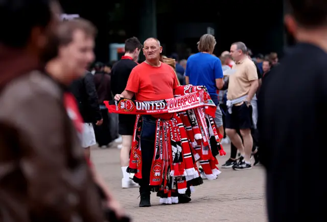 A scarf seller with half and half scarves ahead of the Premier League match