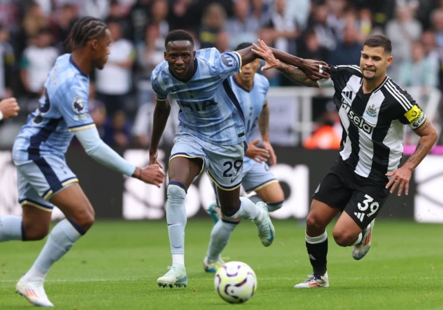 Pape Matar Sarr of Tottenham Hotspur (C) in action against Bruno Guimaraes