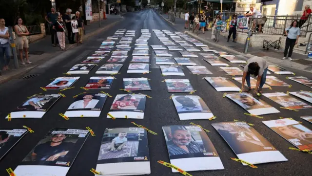 Family members and supporters of hostages who were kidnapped during the deadly October 7 attack, place 107 pictures of hostages outside Israeli Prime Minister Benjamin Netanyahu's residence on Friday