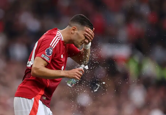 Diogo Dalot of Manchester United wipes his face