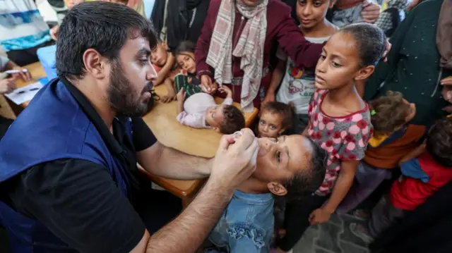 A Palestinian child is vaccinated against polio, at a United Nations healthcare center in Deir Al-Balah