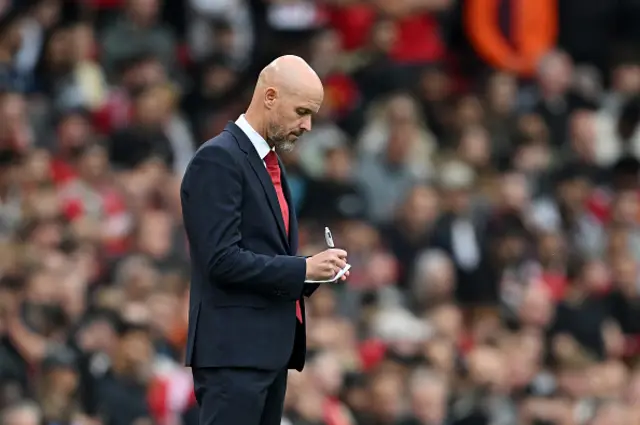 ten Hag writes on a notepad