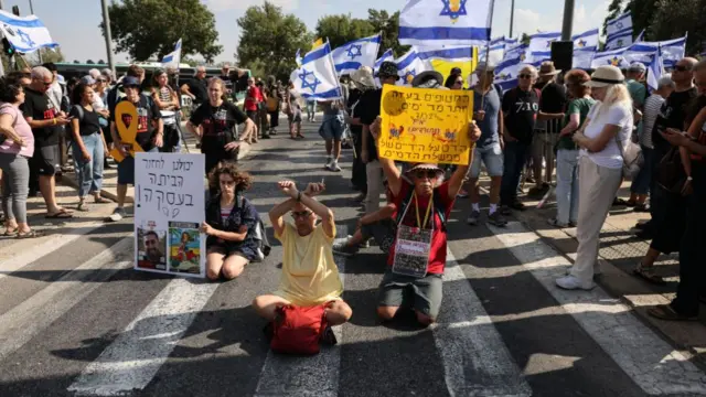 Relatives and supporters of Israeli hostages taken captive in the Gaza Strip since the October 7 attacks by Palestinian Hamas militants, raise flags and placards as they protest outside the prime minister's office in Jerusalem on September 1, 2024