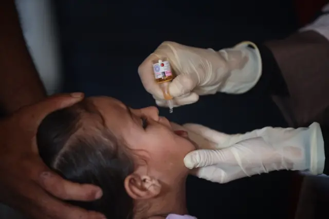 A child receives an oral dose of the polio vaccine