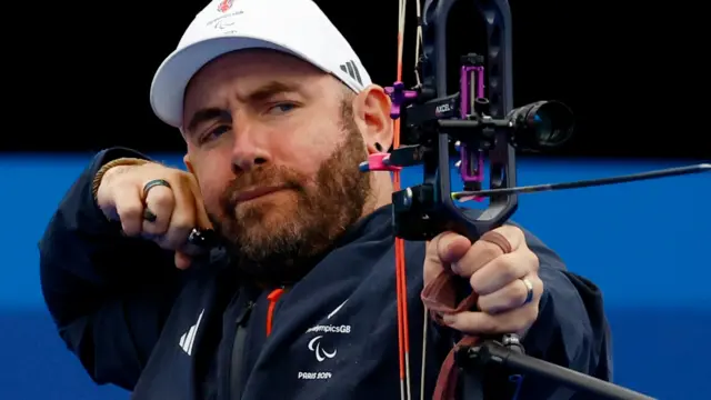 Nathan MacQueen in archery action in Paris