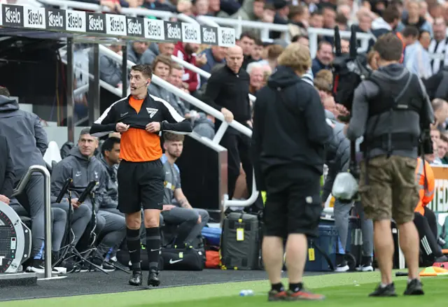 Assistant referee, Ian Hussin, is seen putting on a jacket to become the Fourth Official