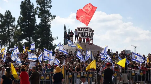 People wave yellow and red flags outside the prime minister's office in Jerusalem during a demonstration